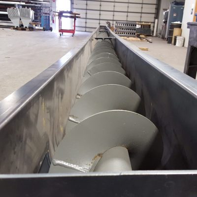 Stainless steel auger flighting inside conveyor trough
